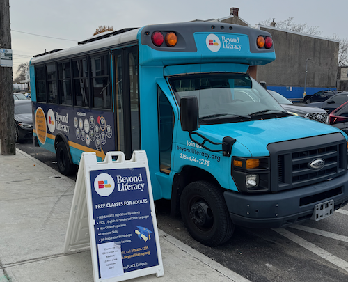 A small blue school bus serving as the Mobile Computer Lab.