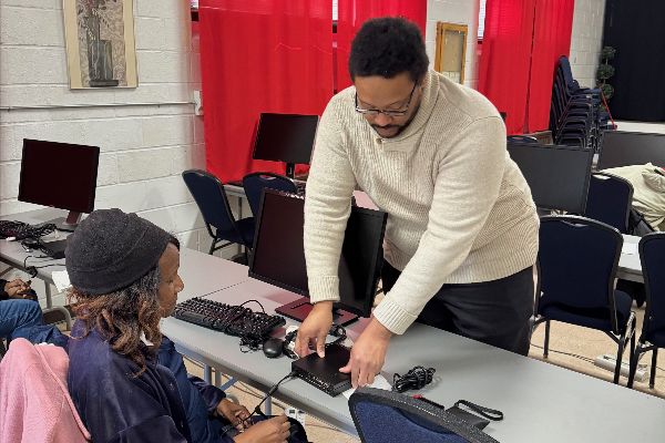 Sean Mitchell working with a learner to set up a desktop computer.